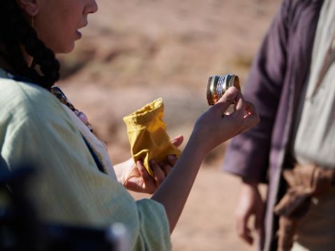 Então o servo tirou joias de ouro e prata e roupas e os deu a Rebeca. Ele também deu presentes caros ao irmão e à mãe dela. – Slide número 17