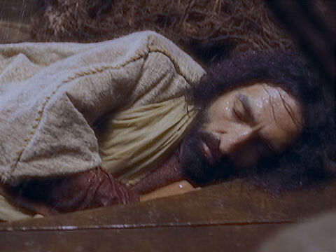 Jesus estava na parte de trás do barco. Ele estava cansado e adormeceu com a cabeça sobre um travesseiro. – Slide número 3